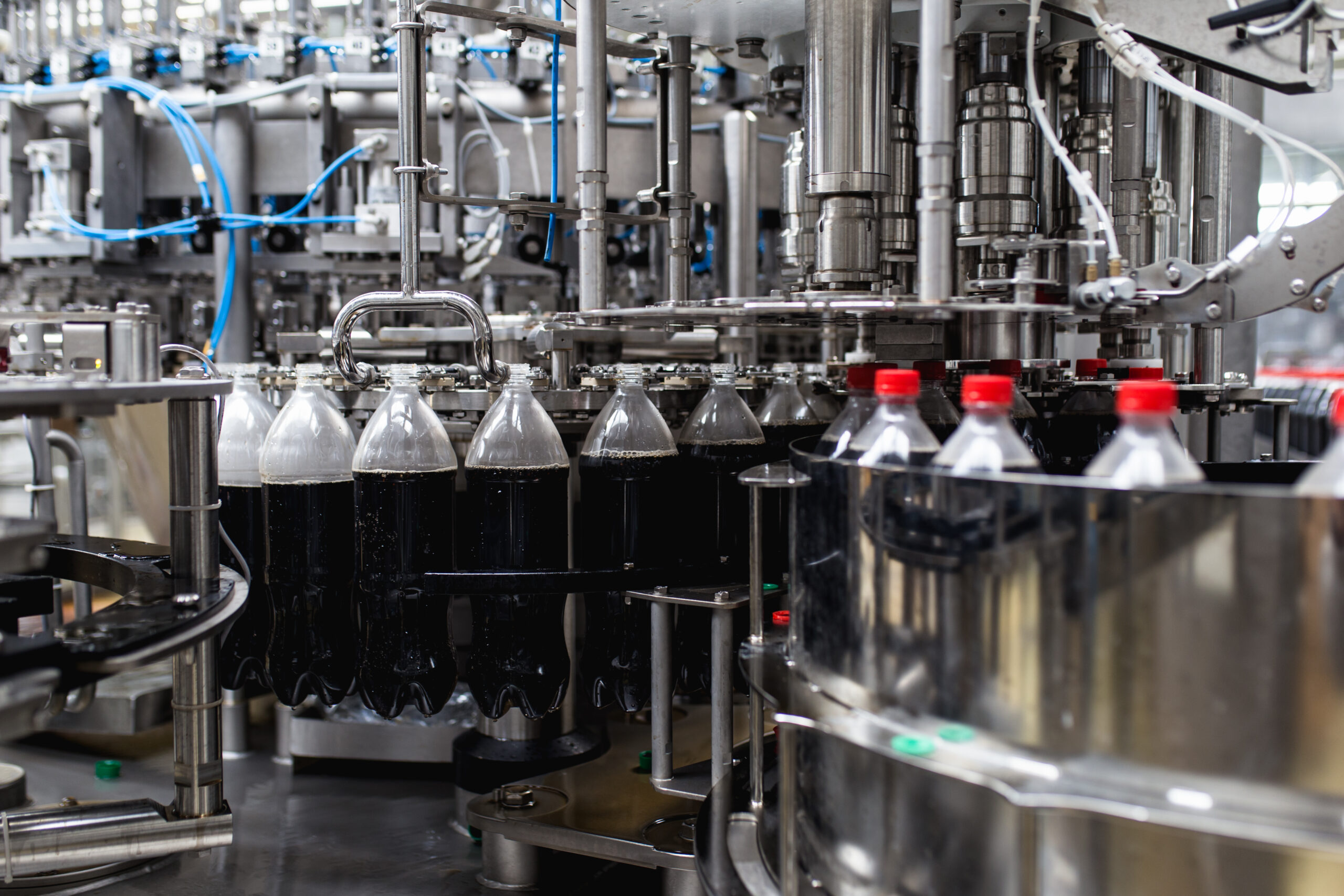 bottling-factory-black-juice-bottling-line-processing-bottling-juice-into-bottles-selective-focus (1)